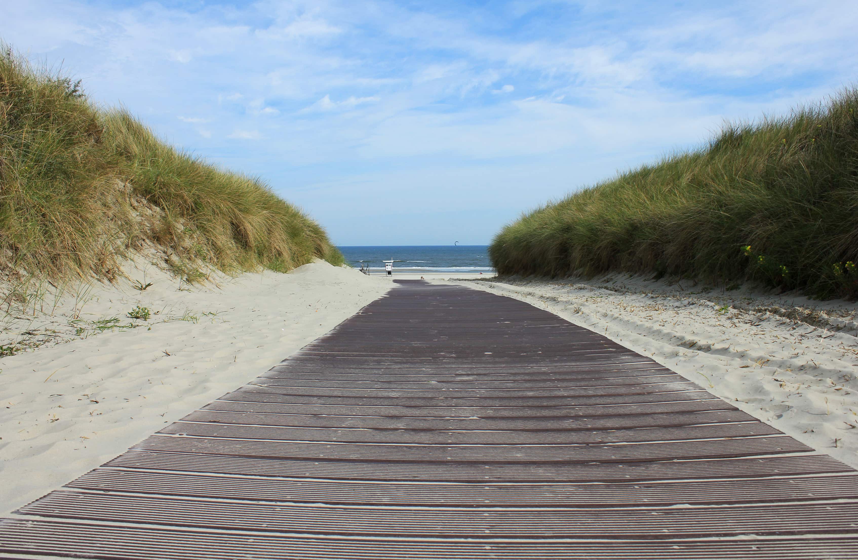 Ein Holzsteg führt durch die Dünen zum kilometerlangen Strand von Juist.