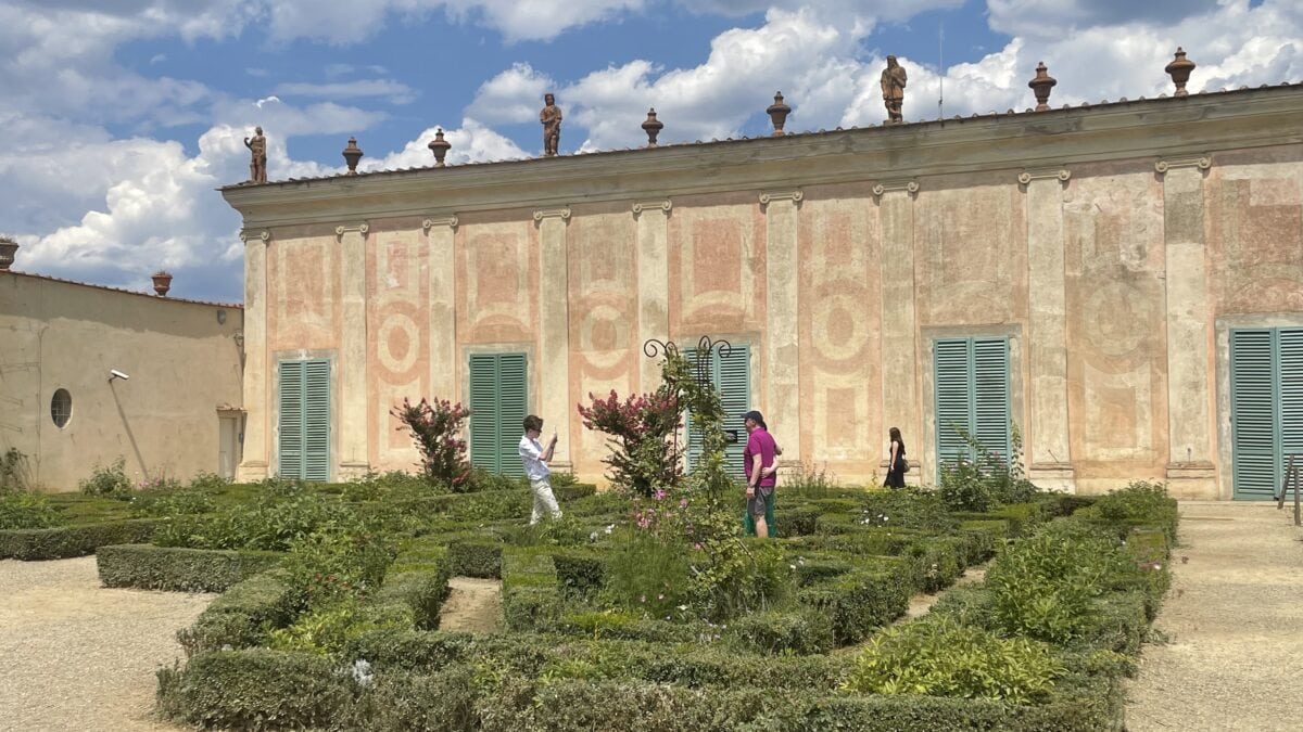 Ein kleines Labyrinth im Boboli-Garten in Florenz mit palastartigem Gebäude im Hintergrund