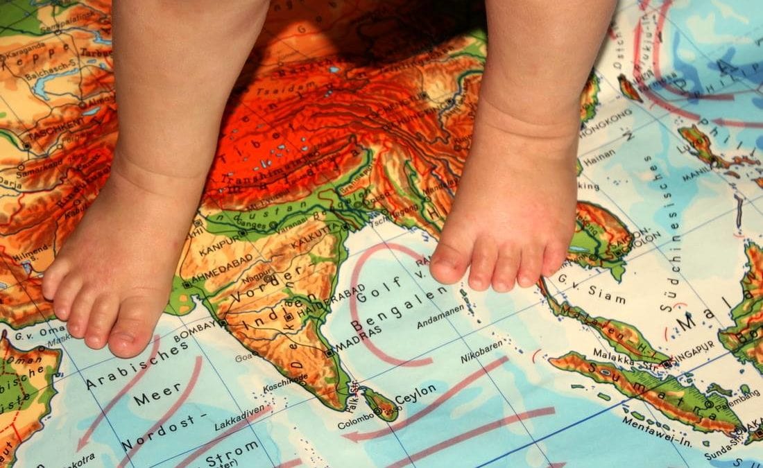 Rubbelbatz, der kleine Sohn von Johanna Bose, mit seinen Füßen auf einer Landkarte