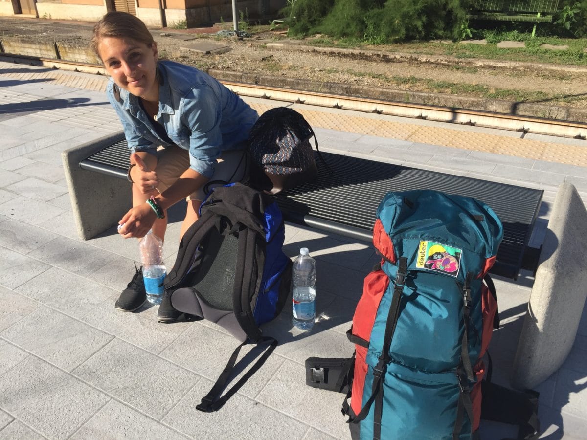 Julia mit Gepäck am Bahnhof