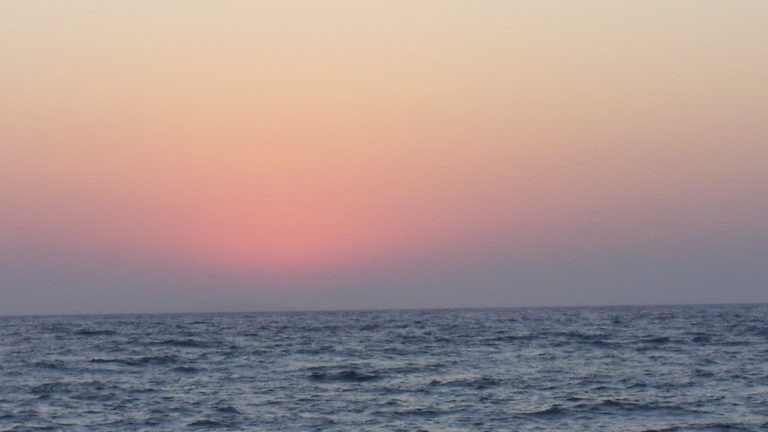 Ein rötlicher Sonnenaufgang über dem Meer
