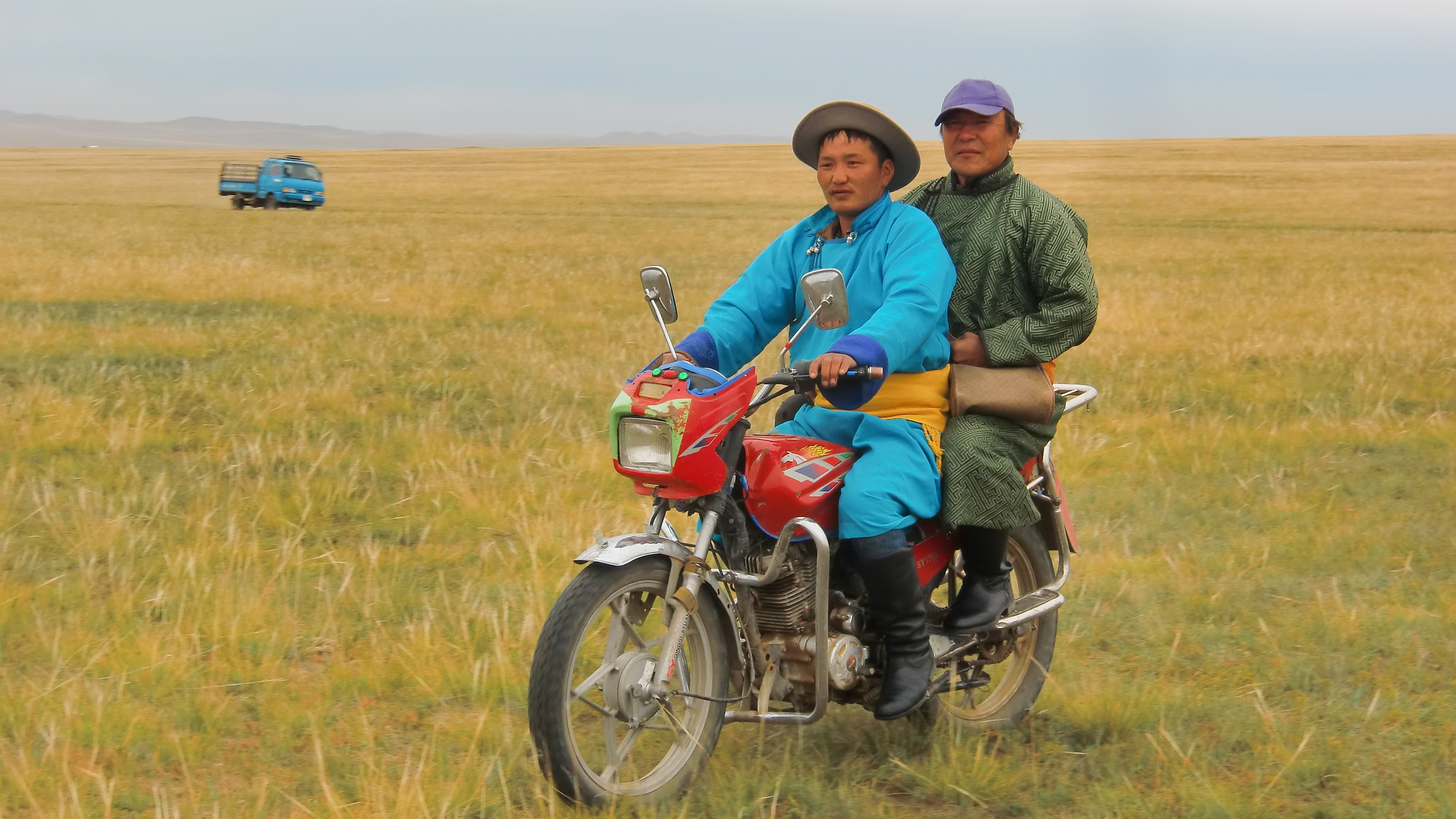 Männer auf einem Motorrad in der Mongolei