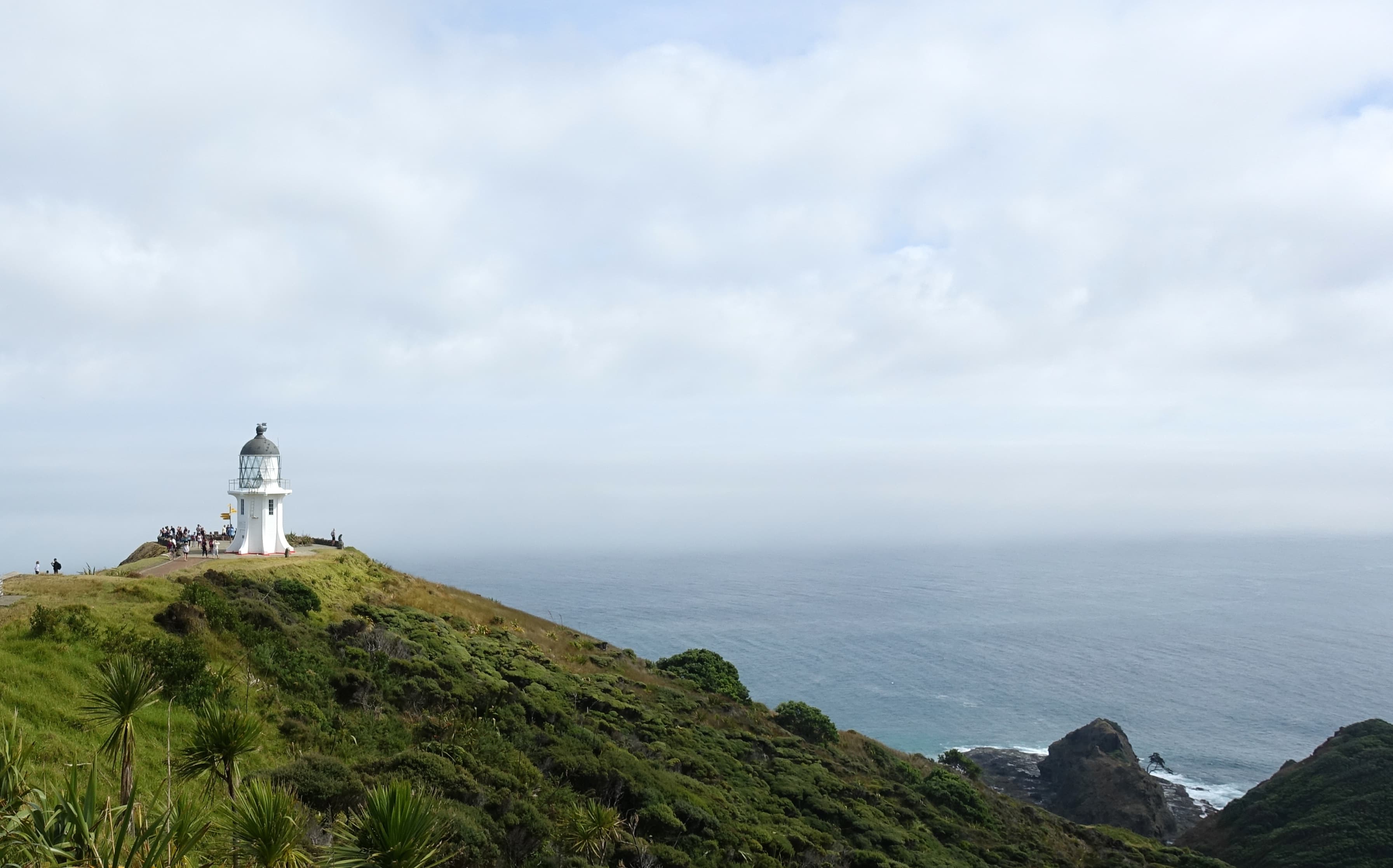 Touristen tummeln sich am Cape Reinga in Neuseeland