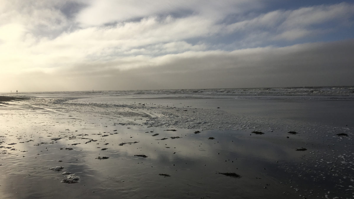 Ein sonnenbeschienener Wolkenhimmel über dem Strand von Sankt Peter Ording in Nordfriesland