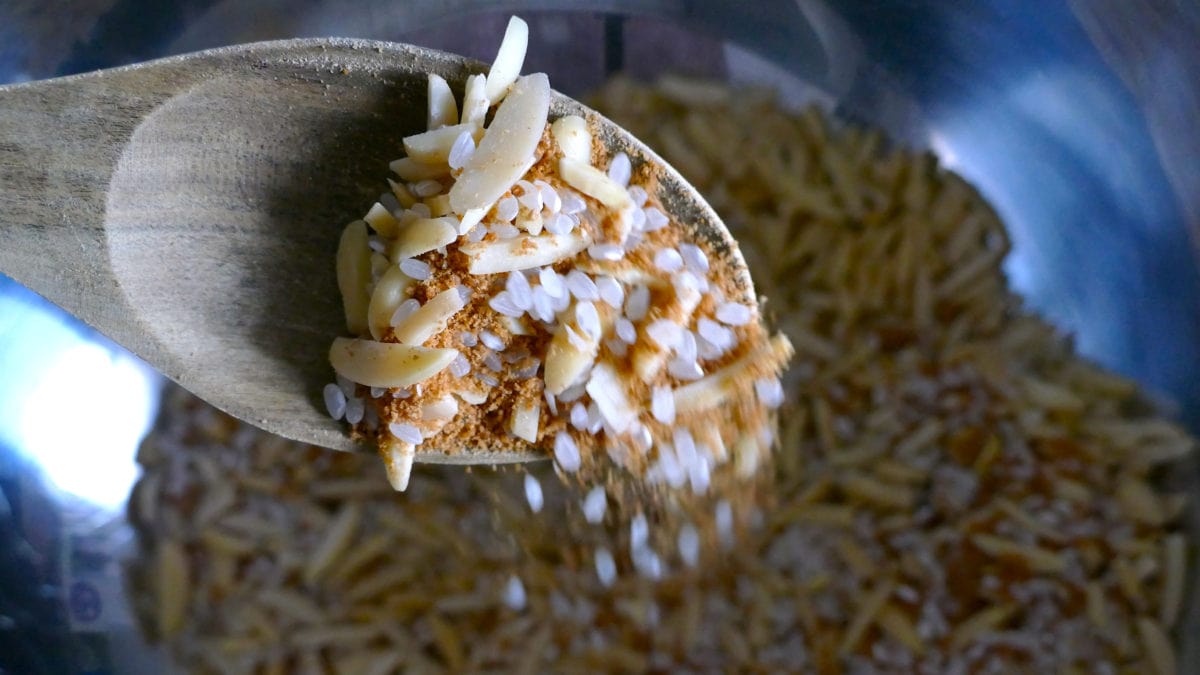 Mit einem Löffel werden die Zutaten für den indonesischen Reispudding vermischt.