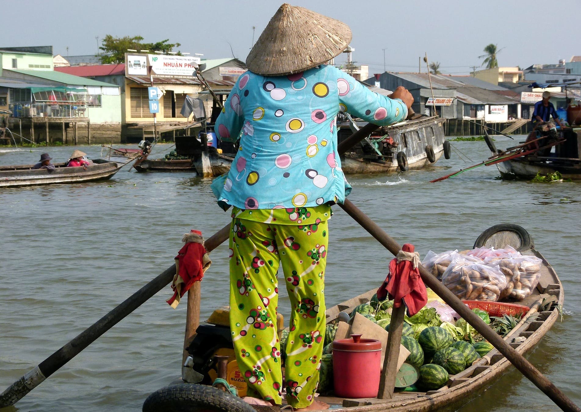 Eine Asiatin mit Schlafanzug auf ihrem Boot in Thailand. Wenn es um die richtige Kleidung an warmen Tagen geht, kann man sich von ihr einiges abschauen.