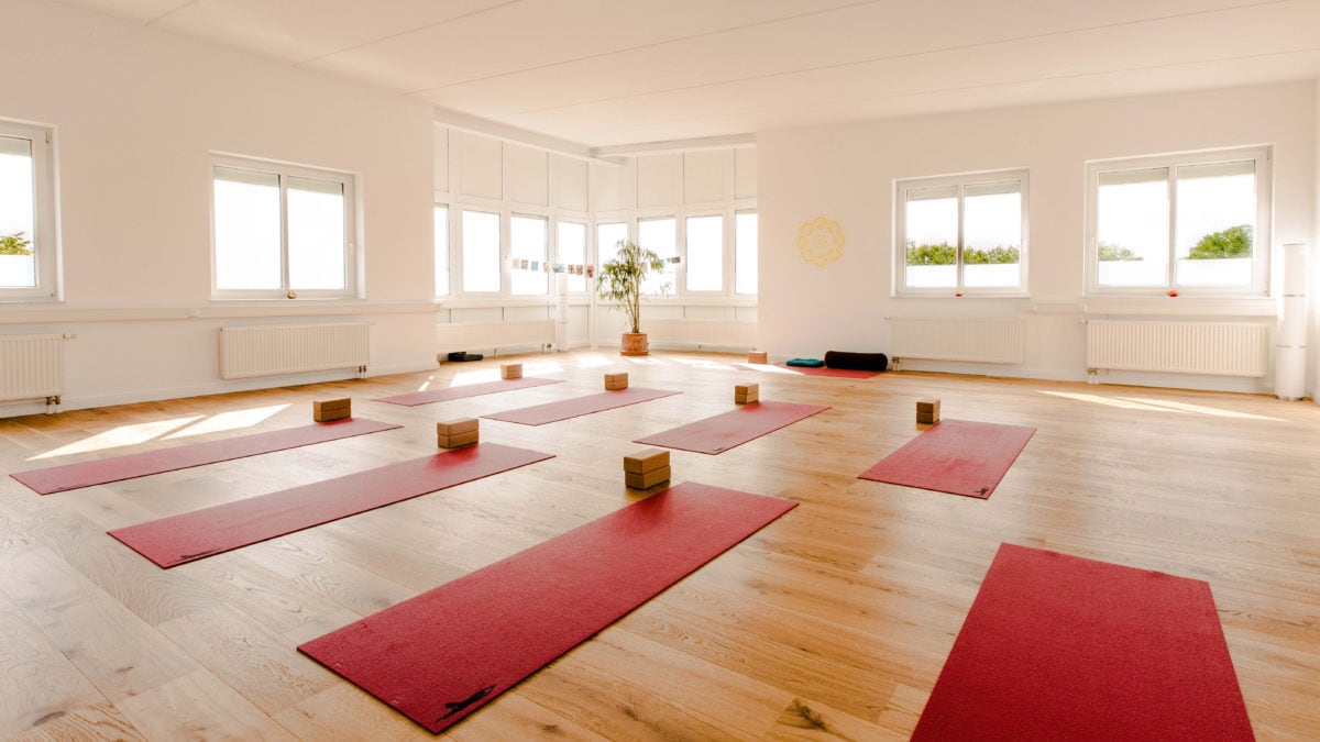 Im Studio von Yoga-Moment sind die roten Yogamatten und Korkblöcke präsent.